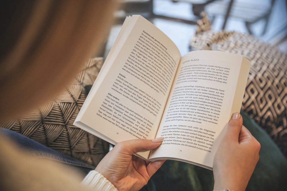 Una mujer lee un libro de bolsillo